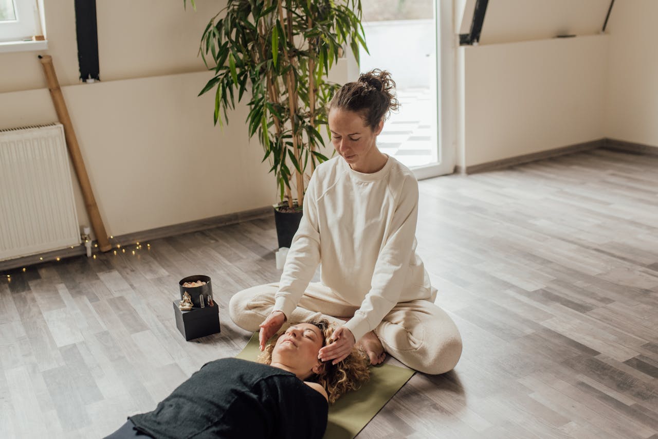 services-01 A calming Reiki session indoors with a therapist and patient on a yoga mat, focusing on healing energy.